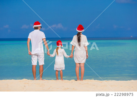 Happy family of three in Santa Hats on beach Happy family of three in Santa Hats on beach 22298975
