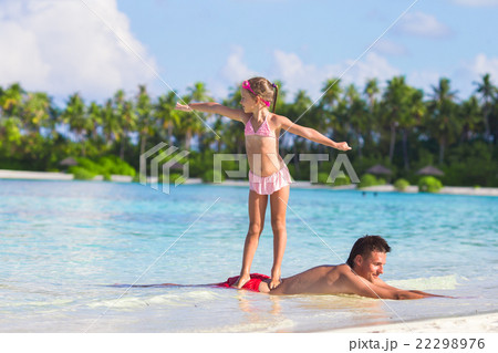 Little girl at beach practicing surfing position 22298976