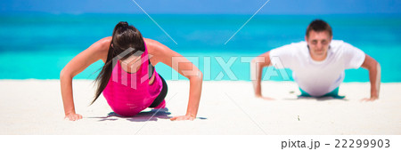 Young fitness couple doing push-ups during outdoor 22299903