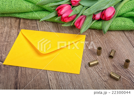 Envelope, tulips and bullets on  wooden background 22300044