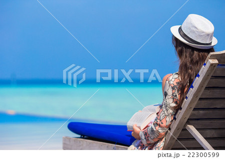 Young woman reading on tropical white beach Young woman reading on tropical white beach 22300599