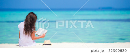Young woman reading on tropical white beach 22300620