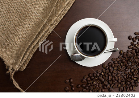 一杯のコーヒーカップとそれを挟むように置かれた麻袋とコーヒー豆 真俯瞰 一杯のコーヒーカップとそれを挟むように置かれた麻袋とコーヒー豆 真俯瞰 22302402