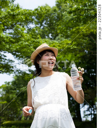 公園で水を飲む妊婦 22304328