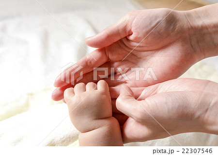 お母さんの指を握る赤ちゃんの手の写真素材