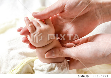 お母さんの指を握る赤ちゃんの手の写真素材