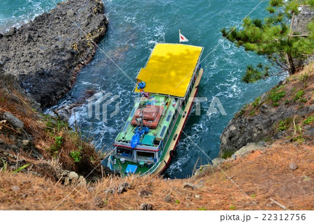 金沢 能登金剛 巌門の上の展望台より見下ろす 巌門に入っていく遊覧船 ２ の写真素材