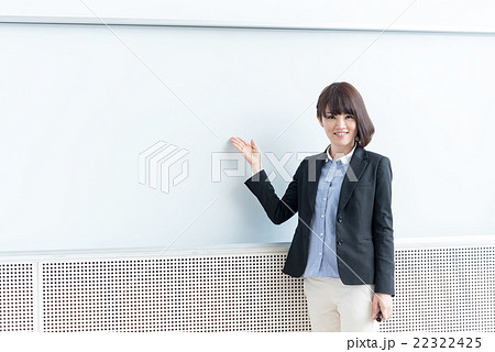 ホワイトボードの前でお薦めポーズをする女性 22322425