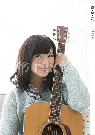 ギターを持つ女性の写真素材