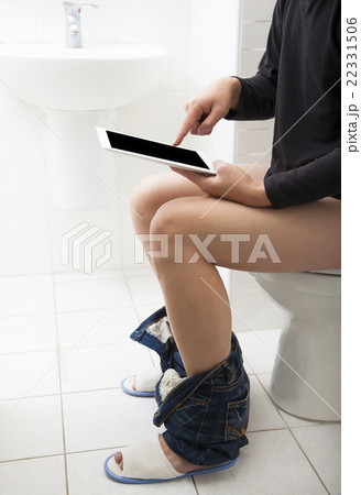 young man in toilet using tablet young man in toilet using tablet 22331506
