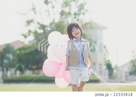Asian child with many balloons playing in the park Asian child with many balloons playing in the park 22333618