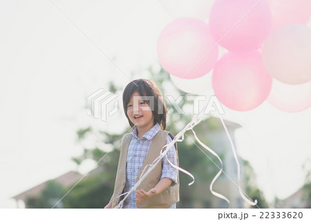 Asian child with many balloons playing in the park 22333620