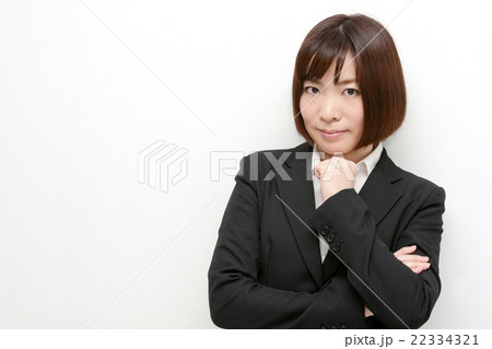 あごに手をやるスーツ姿の女性 22334321