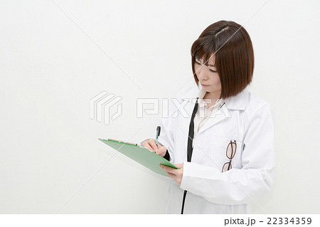 カルテに書き込む白衣の女性 22334359