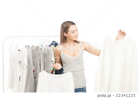 Smiling brunette holding two hangers with shirts Smiling brunette holding two hangers with shirts 22341225