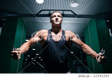 Strong bodybuilder doing chest exercise with cable 22341293