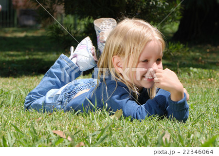 The little girl laying on a grass in park The little girl laying on a grass in park 22346064