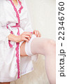 Bride putting a wedding garter on her leg 22346760