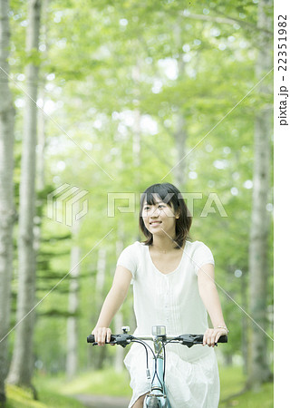 森林の中で自転車に乗る女性の写真素材