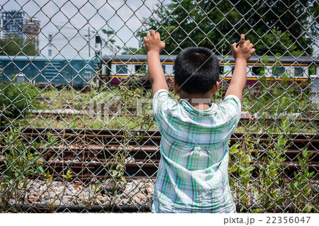 asian little boy sad hand hold jail at Railroad asian little boy sad hand hold jail at Railroad 22356047