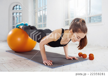 Beautiful slim brunette doing some gymnastics at 22359281