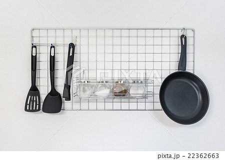 iron frying pan and utensils hanging on the wall 22362663