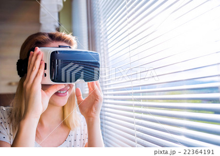 Woman wearing virtual reality goggles standing in Woman wearing virtual reality goggles standing in 22364191