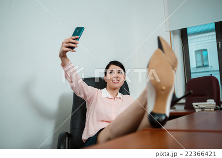 Relaxed business woman sitting in a chair with Relaxed business woman sitting in a chair with 22366421
