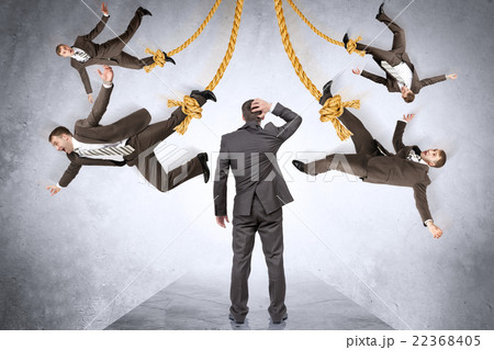 Confused businessman looking on hanging people 22368405