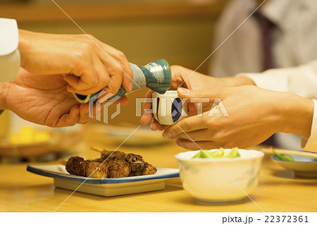 日本酒を注ぐビジネスマン 22372361