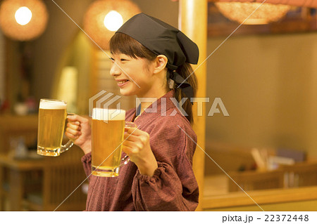 生ビールを運ぶ女性店員 22372448