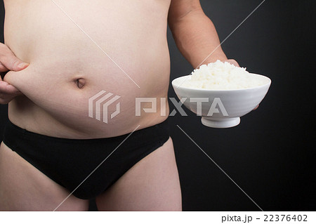 メタボ 腹 ご飯の写真素材