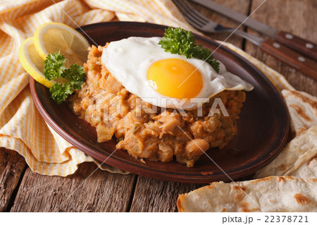 ful medames with a fried egg and pita close up 22378721