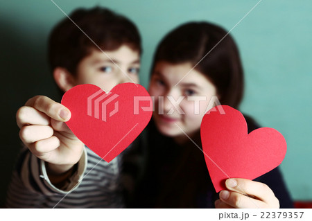 boy and girl hold two red cardboard heart  22379357