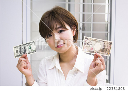 1万円札と100ドル札を持つ若い女性 1万円札と100ドル札を持つ若い女性 22381808