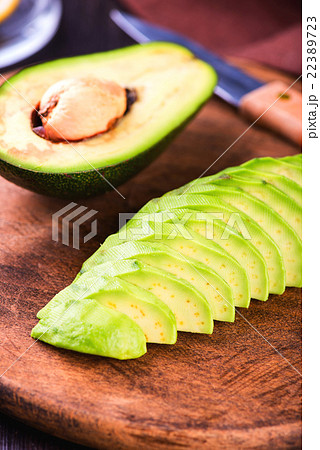 Sliced avocado with knife on cutting board 22389723