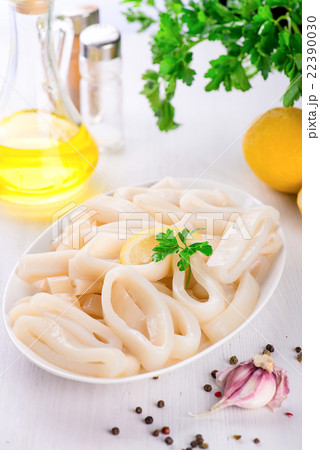 Raw squid rings on white plate, ready to cook Raw squid rings on white plate, ready to cook 22390030