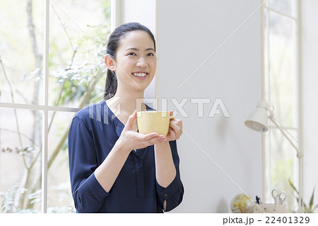 コーヒーカップを持つ日本人女性の写真素材