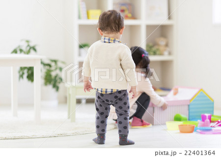 子供部屋で遊ぶ姉弟の後ろ姿の写真素材