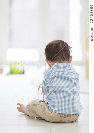 床に座る男の子の後ろ姿の写真素材
