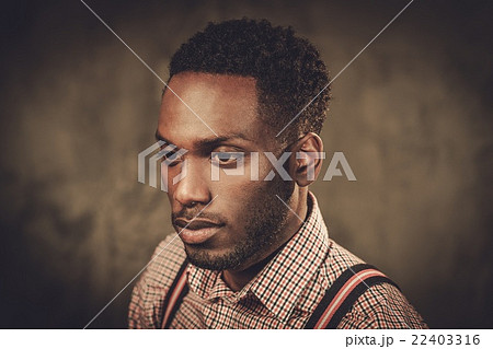 Stylish black man posing on dark background. Stylish black man posing on dark background. 22403316
