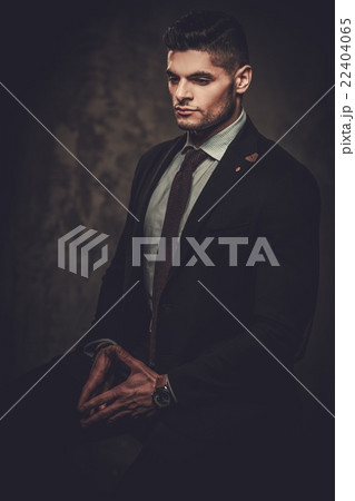 Serious well-dressed hispanic man posing in studio 22404065