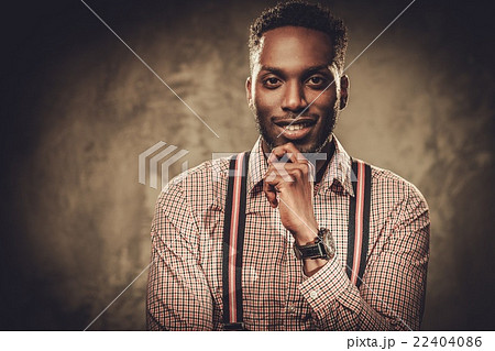 Stylish black man posing on dark background. Stylish black man posing on dark background. 22404086