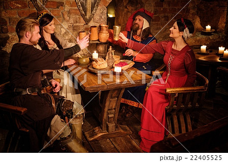 Medieval people eat and drink in castle tavern. Medieval people eat and drink in castle tavern. 22405525