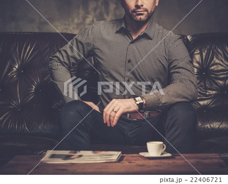 Well-groomed man posing on dark background. 22406721