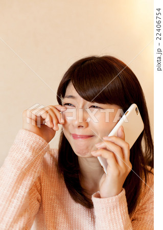 ベッドで携帯で電話をする女性 22406754