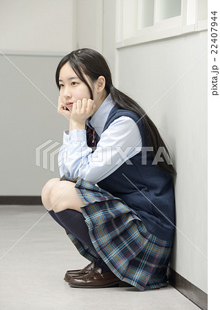 廊下でしゃがむ女子高校生 22407944
