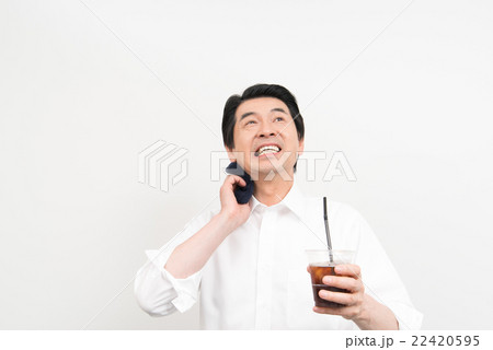 汗を拭きながらアイスコーヒーを飲むビジネスマン 22420595