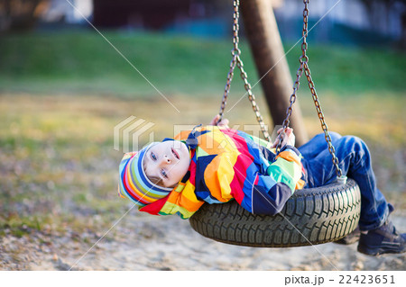 Little kid boy swinging on playground outdoors Little kid boy swinging on playground outdoors 22423651