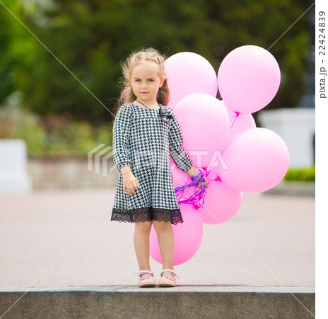Little girl holding pink balloons Little girl holding pink balloons 22424839